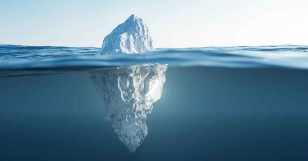 full iceberg floating in the ocean showing parts above and below the water line
